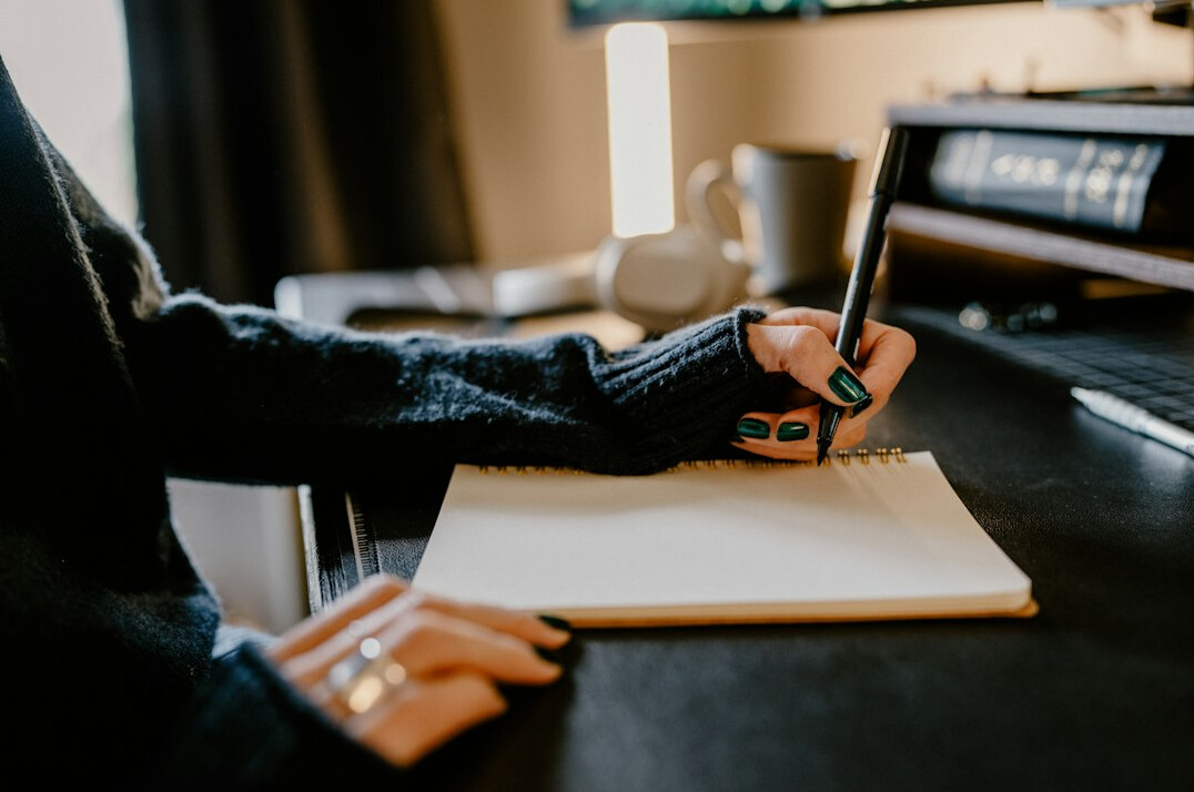 woman writing novel at desk