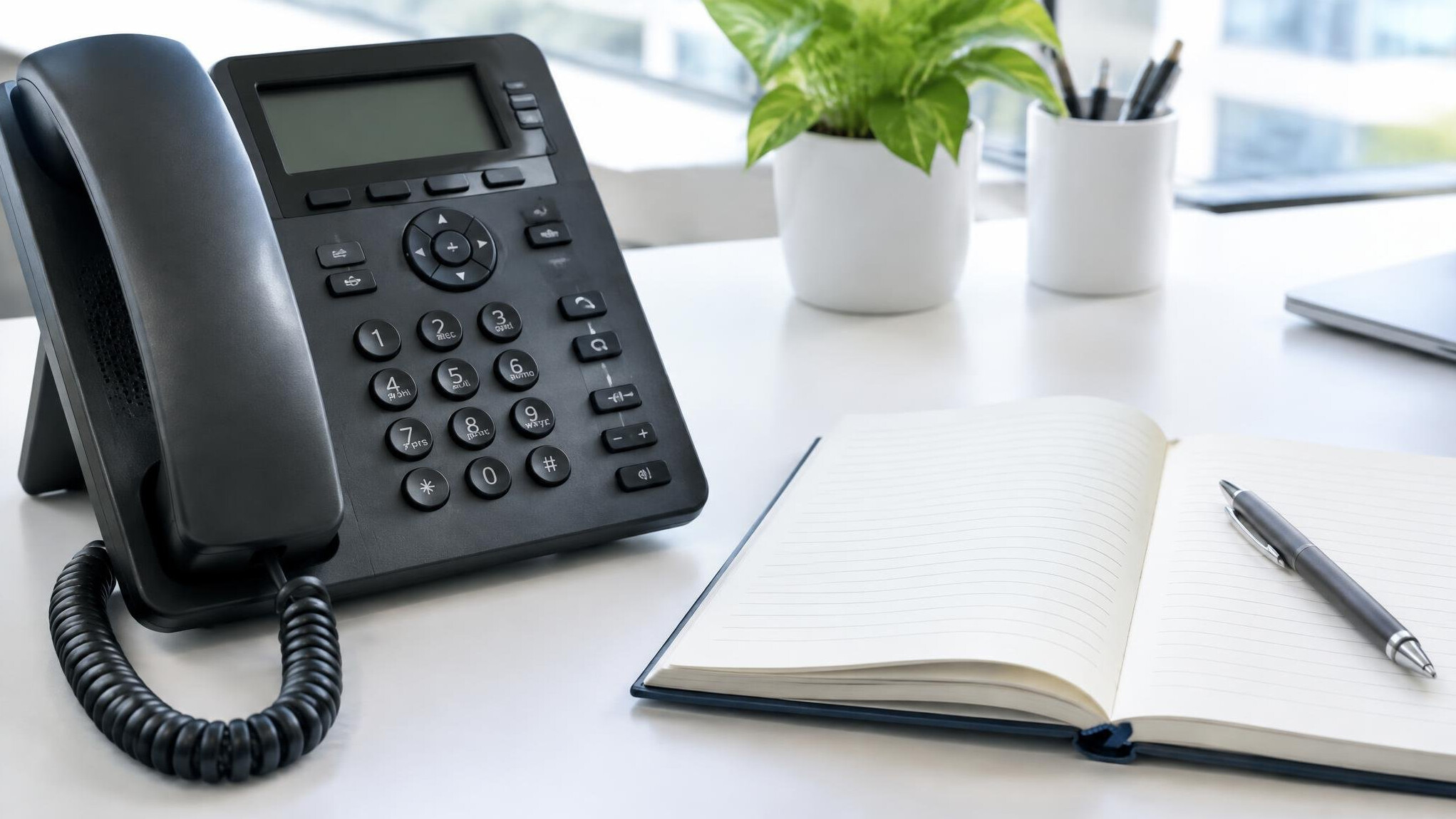 Telephone and notebook resting on an office desk