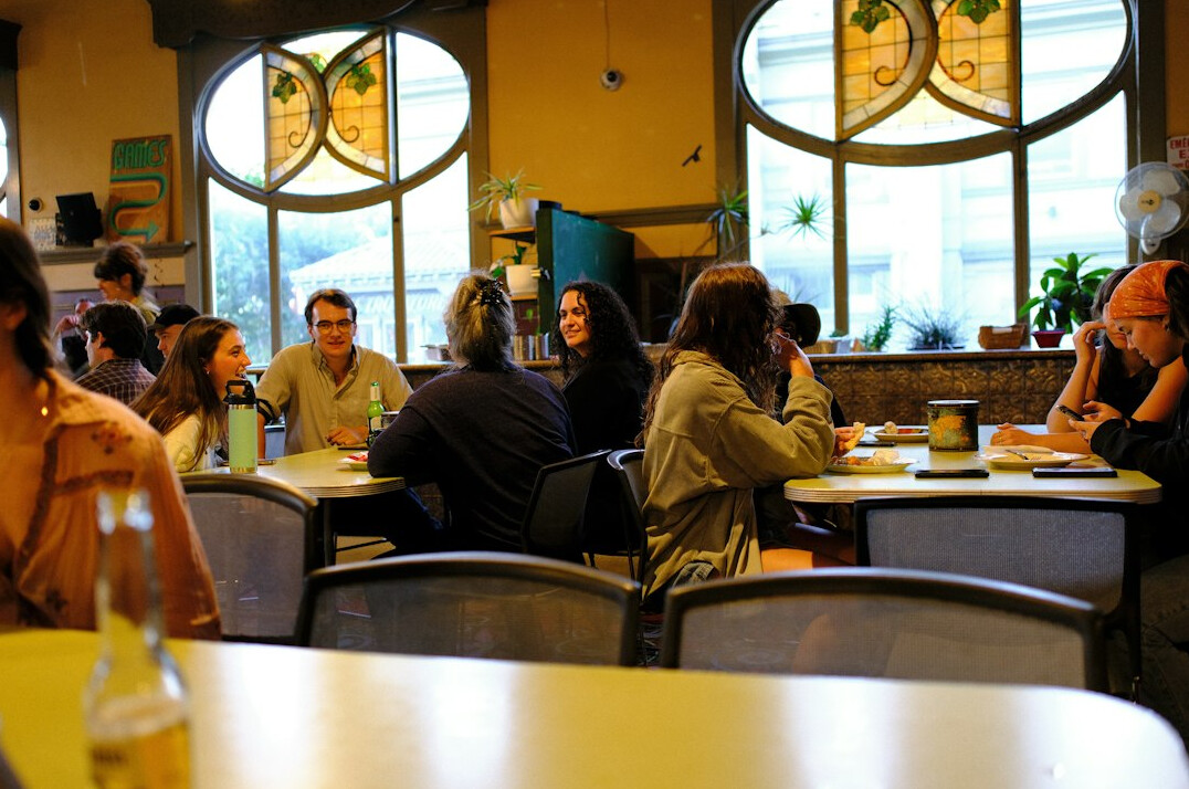 Small editorial team having a discussion around a table